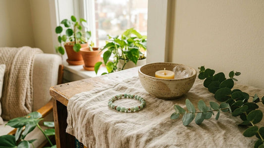 Amazonite bracelet on linen beside a candle and plants in a quiet apartment