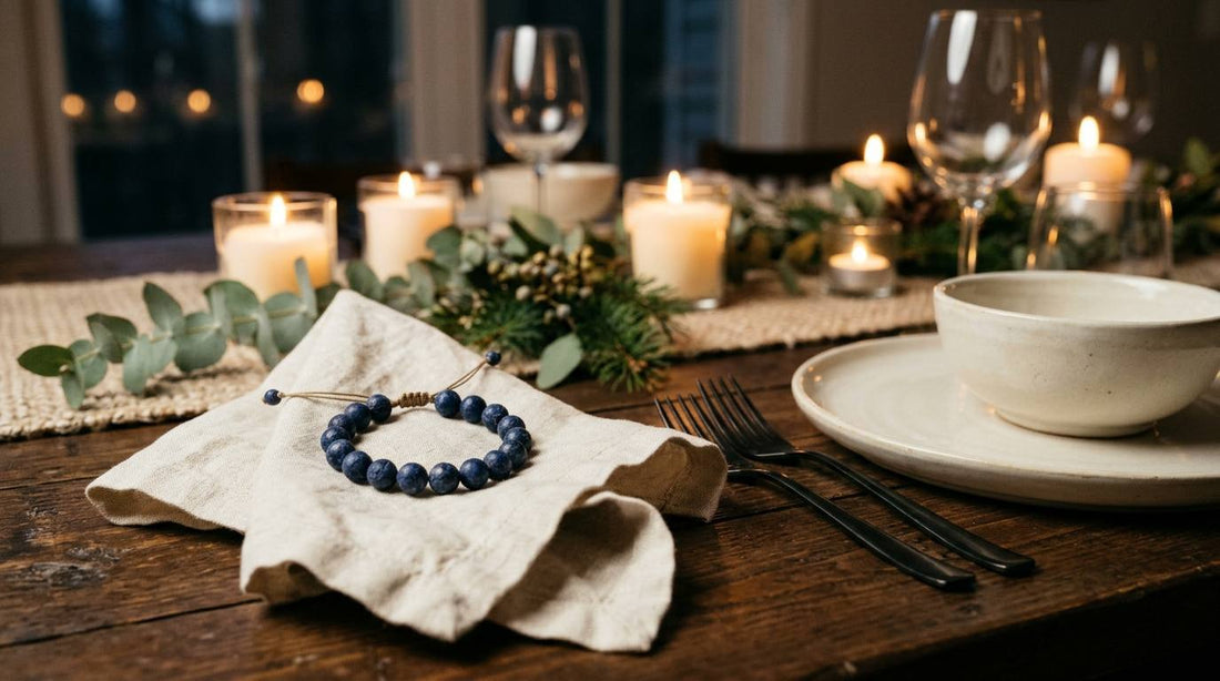 Deep blue stone bead bracelet on linen beside candlelit holiday dinner table settings