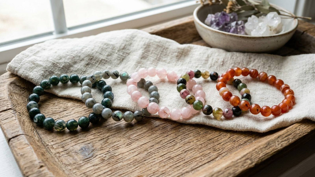 Natural gemstone bead bracelets with varied colors and markings on linen and a wooden tray