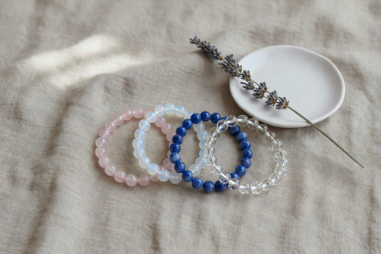 Flat lay of calming crystal bracelets on linen with dried lavender